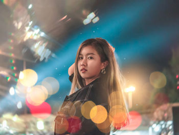 Portrait of girl standing in illuminated during winter