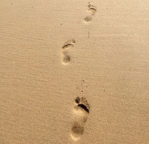 High angle view of footprints on sand at beach