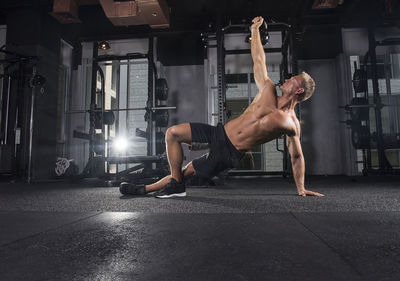 Young man exercising with kettlebell at gym