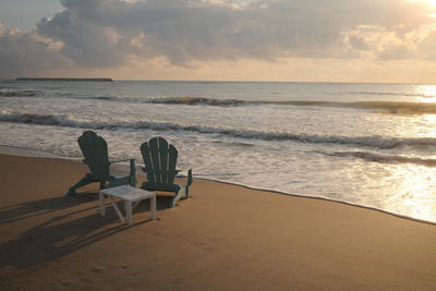 Silhouette people at beach against sky during sunset