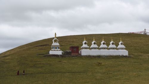 Built structure on field against sky