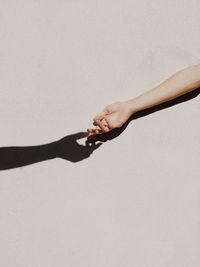 Midsection of woman holding hands against white background
