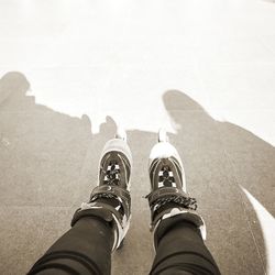 Low section of person wearing roller skates on floor