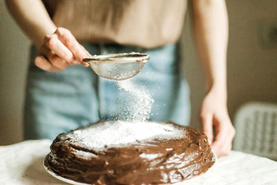 Woman cooking a chocolate cake in kitchen at home.