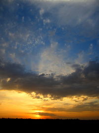 Scenic view of dramatic sky over silhouette landscape