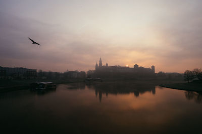 View of buildings at waterfront against cloudy sky