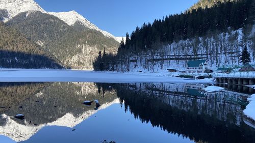 Scenic view of lake by snowcapped mountains against sky