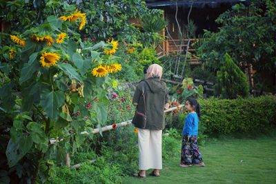 Rear view of women standing on plants