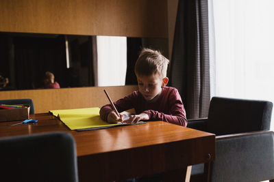 Boy doing homework at table