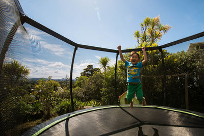 Boy playing in park against sky