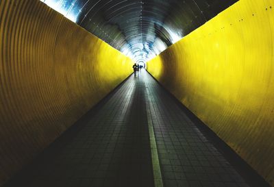 Person walking in illuminated tunnel