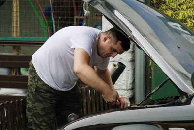 Young man standing in car