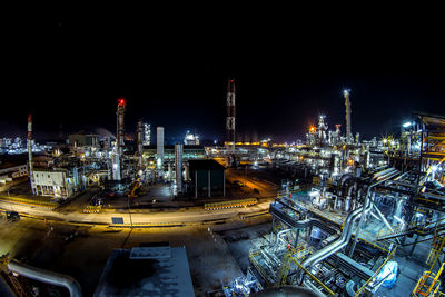 High angle view of illuminated factory against sky at night