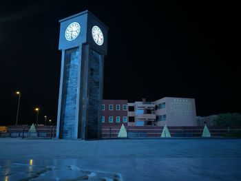 Illuminated clock tower against sky at night