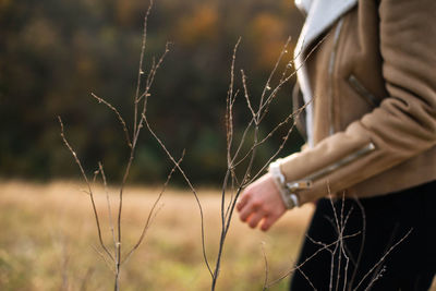 Midsection of woman standing on field