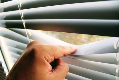 Cropped image of hand on blinds
