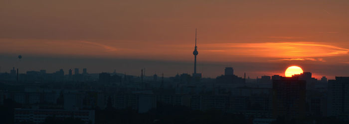 Silhouette of buildings against orange sky