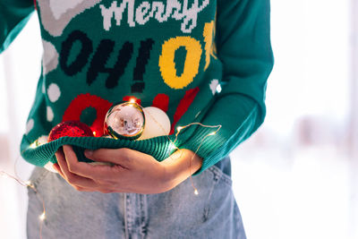 Midsection of woman holding christmas decoration