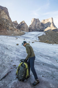 Man on snow covered mountain against sky