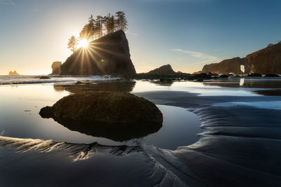 Evening sun on tide pool in pacific ocean with sea stacks looming