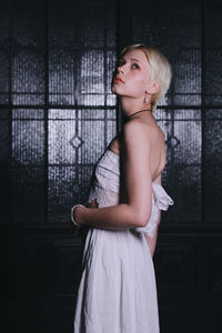 Young woman standing against window