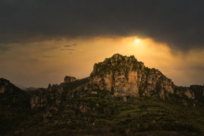 Rock formation on mountain against sky during sunset