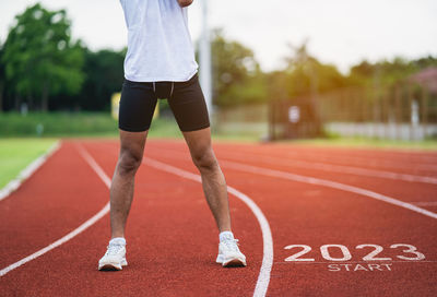 Low section of woman exercising on soccer field