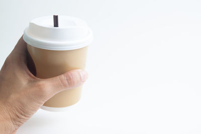 Cropped image of person holding coffee cup against white background