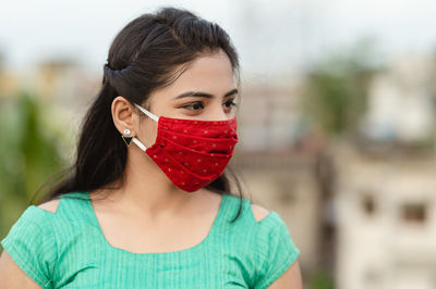 Close-up of woman wearing red mask