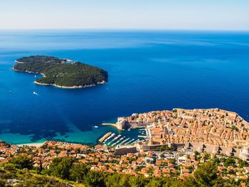 High angle view of sea by cityscape against sky