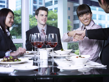 Colleagues with drinks at restaurant during meeting