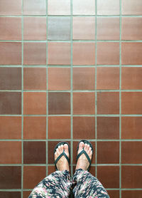 Low section of woman standing on tiled floor