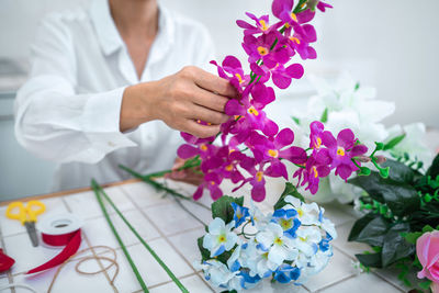 Midsection of bride holding bouquet