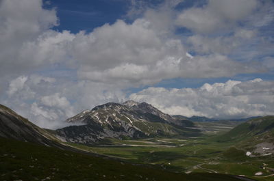 Scenic view of mountains against cloudy sky
