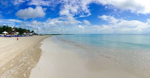 Scenic view of beach against cloudy sky