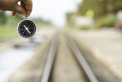 Close-up of hand holding metal railroad track