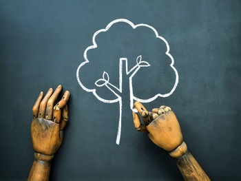 Close-up of human hand with text on blackboard