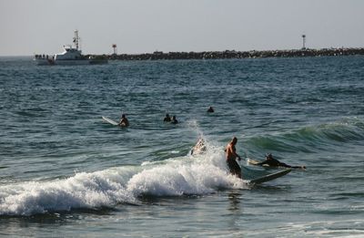 People on sea against clear sky
