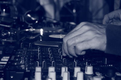 Cropped hand of man mixing sound in recording studio