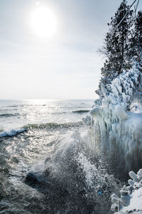 Waves crashing on ice covered shoreline at cave point park door county wisconsin in winter