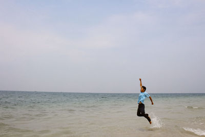 Man surfing in sea against sky