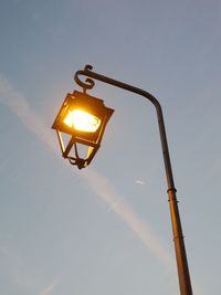 Low angle view of illuminated street light against sky