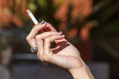 Close-up of hand holding cigarette