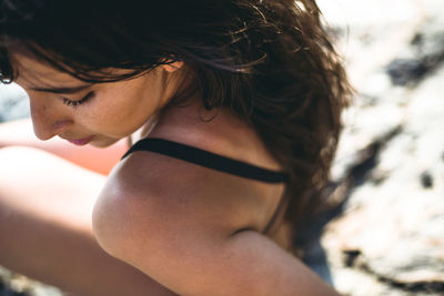 Detail of young latina woman by the ocean at golden hour in summertime