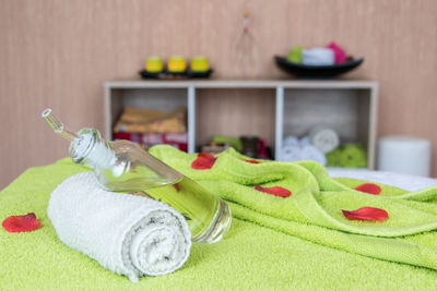 Close-up of spray bottle with towel on bed