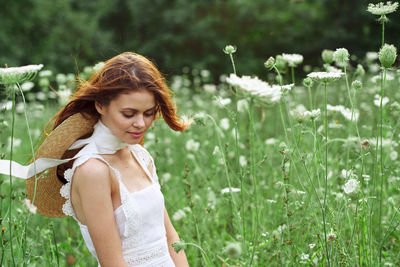 Portrait of smiling young woman standing against plants