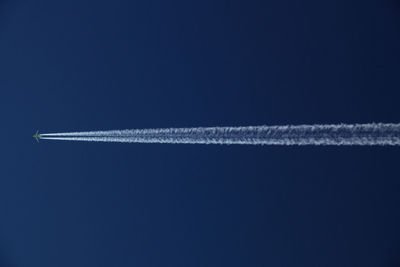 Low angle view of airplane flying against blue sky