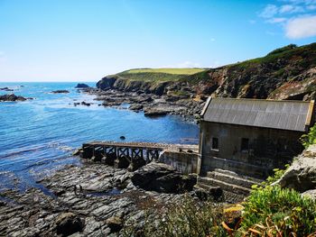 Scenic view of sea against sky with an old lifeboat station on the lizard 