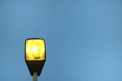 Low angle view of illuminated lamp against clear sky