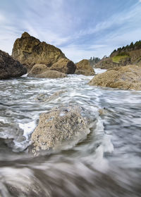 Scenic view of rocks in sea against sky